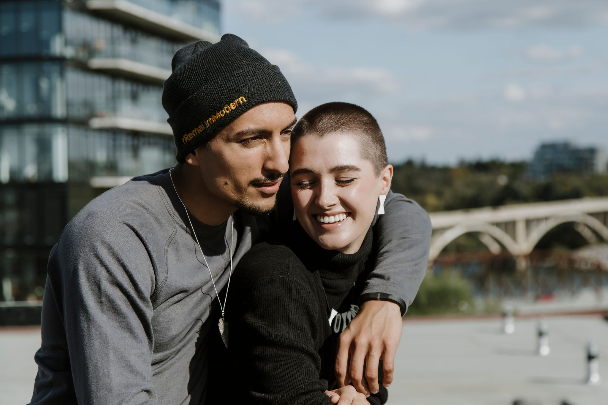 Two people stand on the roof of Remai Modern looking out at the South Saskatchewan River on a fall afternoon.